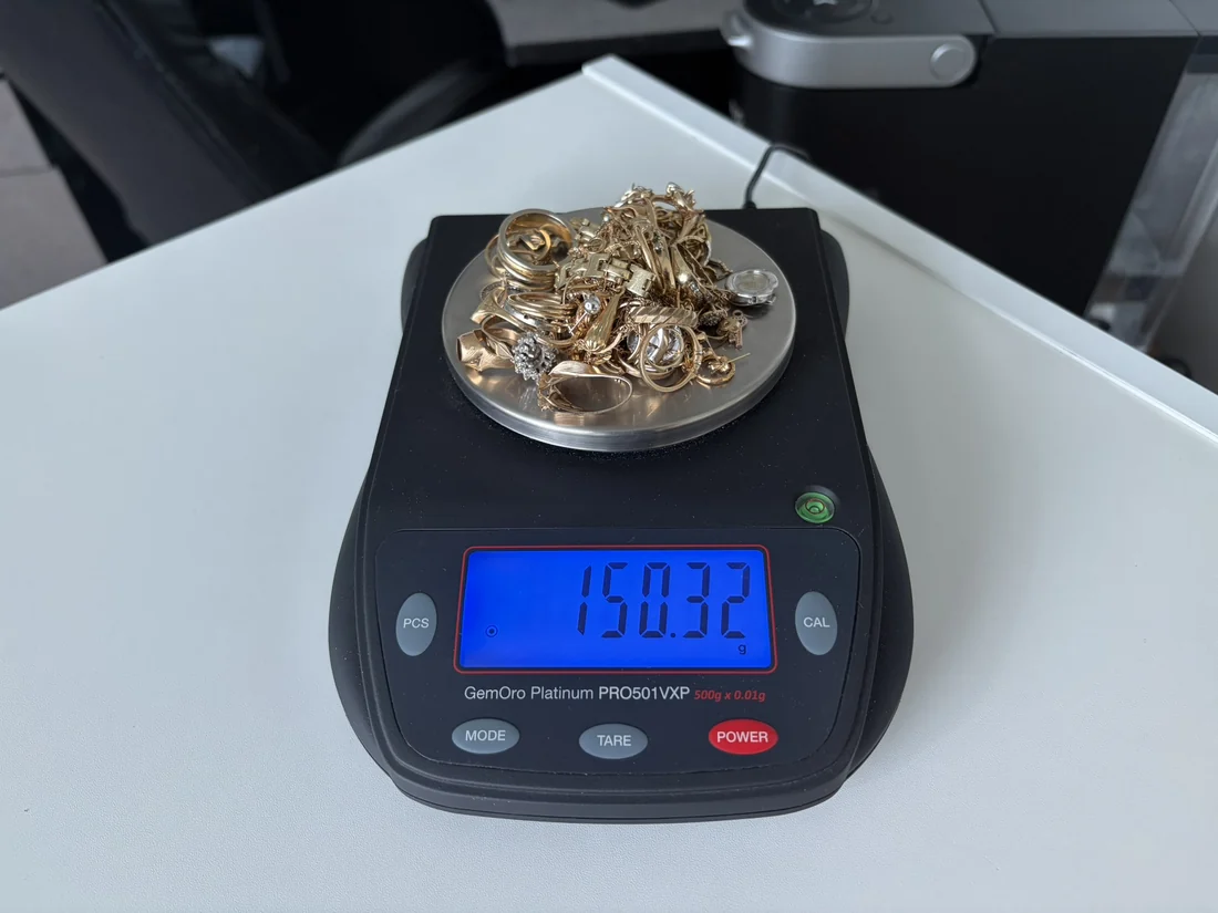 Gold jewellery on the counter scale reading 150.32 grams
